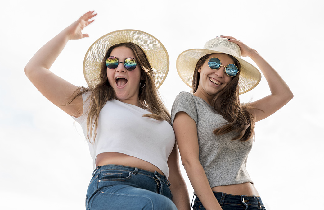 jeunes filles qui s'amusent et porte un chapeau et des lunettes publicitaires